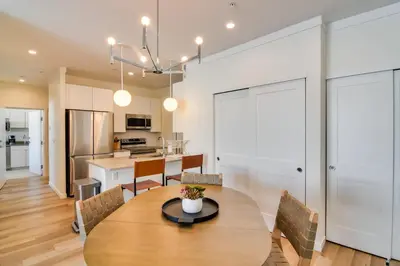 a kitchen and dining room with a wooden table and chairs at 2 Mi to Fraser Tubing Hill Condo with Fireplace! in Fraser