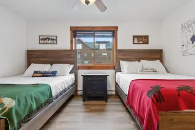 two beds sitting next to each other in a room at The Loose Moose Lodge in Grand Lake
