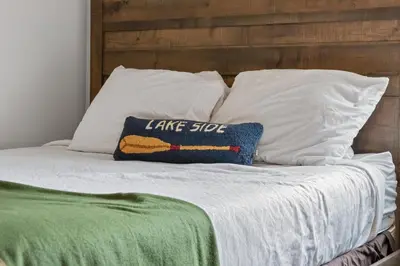 a bed with white pillows and a blue pillow with a lake slope at The Loose Moose Lodge in Grand Lake