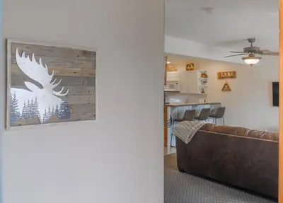 a living room with a couch and a painting on a wall at The Loose Moose Lodge in Grand Lake