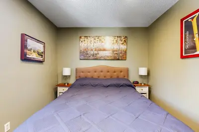 a bedroom with a purple bed with two night stands at Hi Country Haus Haven in Winter Park