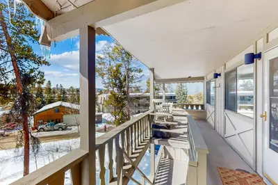 a balcony with tables and chairs on a house at Hi Country Haus Haven in Winter Park