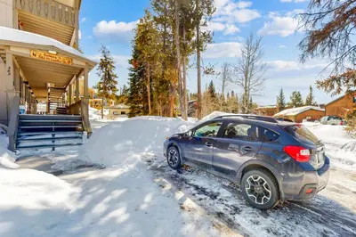 a car parked in the snow in front of a house at Hi Country Haus Haven in Winter Park