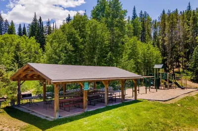 a pavilion with tables and benches in a park at Hi Country Haus Haven in Winter Park
