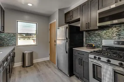 a kitchen with a stainless steel refrigerator and a window at 7 Mi to Denver Inviting Aurora Home with Yard! in Aurora
