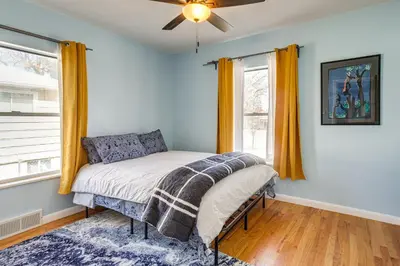 a bedroom with a bed and two windows at 7 Mi to Denver Inviting Aurora Home with Yard! in Aurora
