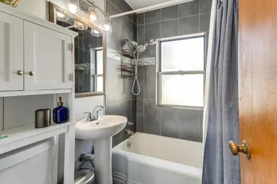 a bathroom with a sink and a tub and a window at 7 Mi to Denver Inviting Aurora Home with Yard! in Aurora