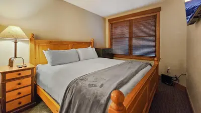 a bedroom with a bed and a lamp and a window at River Run 2BD Condo Walk to Ski and Lift in Keystone