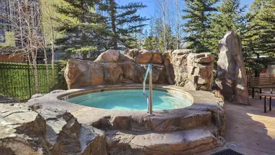 a small pool with a rock wall around it at River Run 2BD Condo Walk to Ski and Lift in Keystone