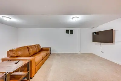 a living room with a brown couch and a flat screen tv at 10 Mi to Denver Pet-Friendly Arvada Home with Yard! in Arvada
