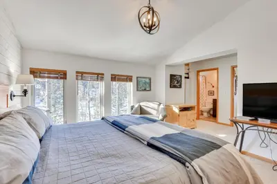a bedroom with a large bed and a flat screen tv at Fantastic Fraser Condo Year-Round Family Getaway in Fraser