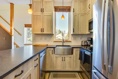 a kitchen with wooden cabinets and a stainless steel sink at Fantastic Fraser Condo Year-Round Family Getaway in Fraser