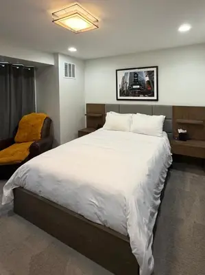 a bedroom with a large white bed and a chair at Modern Luxury Home I Sleeps 8 I 10min to Downtown in Denver