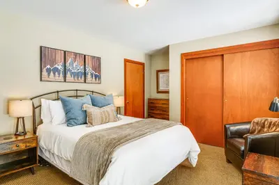 a bedroom with a large bed and a chair at Downtown Frisco Townhome about 1 Mi to Lake Dillon! in Frisco