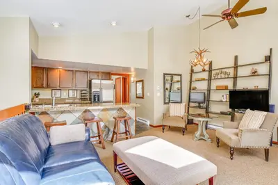 a living room with a blue couch and a kitchen at Downtown Frisco Townhome about 1 Mi to Lake Dillon! in Frisco