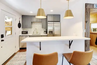 a kitchen with a white counter and two chairs at Skipper's Cabin in Pine
