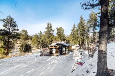 a cabin in the snow next to a tree at Skipper's Cabin in Pine
