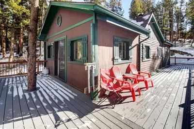 a deck with two chairs and a table and a house at Skipper's Cabin in Pine