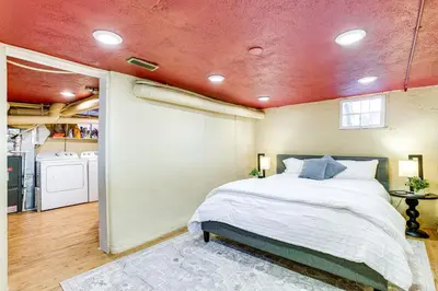 a bedroom with a bed and a washer and dryer at 4 Mi to Downtown Denver Washington Park Hideaway! in Denver