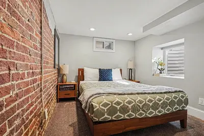 a bedroom with a bed and a brick wall at 5-Bedroom Victorian Home Private Yard Sleeps 10 in Denver