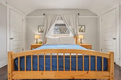 a bedroom with a wooden bed with a window at 5-Bedroom Victorian Home Private Yard Sleeps 10 in Denver