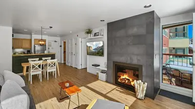 a living room with a fireplace and a kitchen at Lakeside 1BR 4-Min to Keystone Ski Resort in Keystone