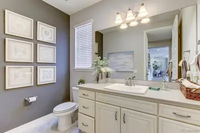 a bathroom with a sink and a toilet and a mirror at Stunning Golf Course View in Denver in Denver
