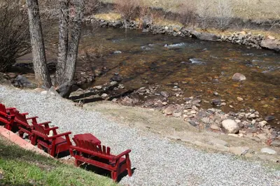 a row of red benches next to a river at Argo Inn and Suites in Idaho Springs