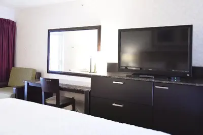 a hotel room with a television and a desk with a bed at Argo Inn and Suites in Idaho Springs