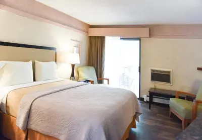 a hotel room with a large bed and a window at Argo Inn and Suites in Idaho Springs
