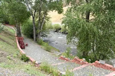a river with a bench next to a river gmaxwell gmaxwell gmaxwell gmaxwell gmaxwell at Argo Inn and Suites in Idaho Springs