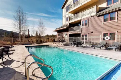a swimming pool with chairs next to a building at Red Hawk Lodge 2 Bedroom Condo In River Run Village in Keystone