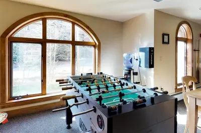 a room with a large pool table in front of a window at Red Hawk Lodge 2 Bedroom Condo In River Run Village in Keystone