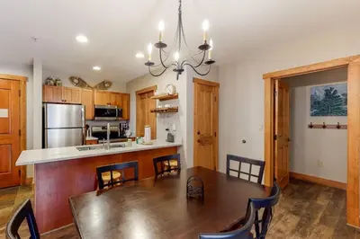 a kitchen with a wooden table and a dining room at Red Hawk Lodge 2 Bedroom Condo In River Run Village in Keystone