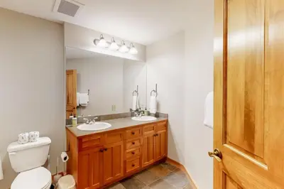 a bathroom with a toilet and a sink and a mirror at Red Hawk Lodge 2 Bedroom Condo In River Run Village in Keystone