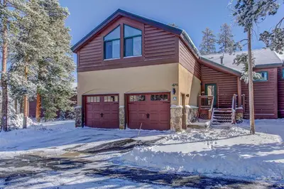 a house with red garage doors in the snow at WaterDance #475A in Frisco