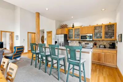 a kitchen with wooden cabinets and green chairs at WaterDance #475A in Frisco