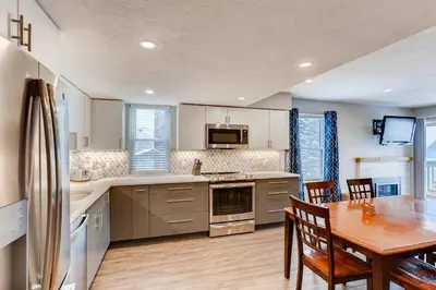 a kitchen and dining room with a table and a refrigerator at Mountainside #272H in Frisco