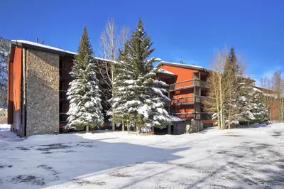 a building with snow covered trees in front of it at Mountainside #162H in Frisco