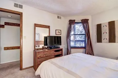 a bedroom with a bed and a tv and a mirror at Mountainside #162H in Frisco