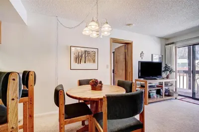 a living room with a table and chairs and a television at Mountainside #162H in Frisco