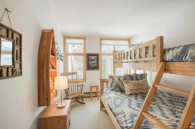a bedroom with a bunk bed and a desk at River Glen #106C in Frisco