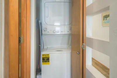 a washer and dryer sitting inside of a room at River Glen #106C in Frisco