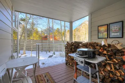 a screened in porch with a grill and a pile of wood at River Glen #106C in Frisco