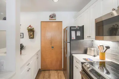 a kitchen with a refrigerator and a wooden door at River Glen #106C in Frisco