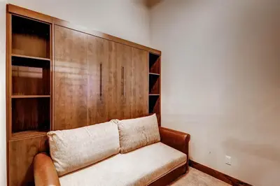 a couch in a room with a wooden wall at Boulevard Bend P2 in Frisco