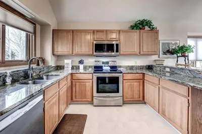 a kitchen with wooden cabinets and stainless steel appliances at Pitkin Townhome 704 in Frisco