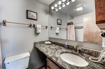 a bathroom with a sink and a toilet and a mirror at Pitkin Townhome 704 in Frisco