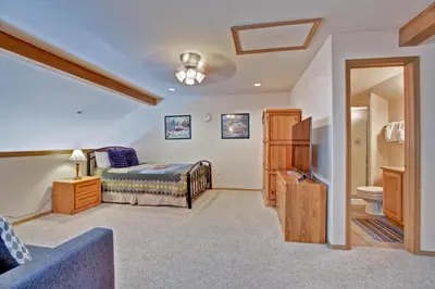 a bedroom with a bed and a bathroom at Tarn Landing C-4 in Frisco