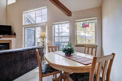 a dining room with a table and chairs and windows at Tarn Landing C-4 in Frisco